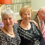 Roland Hall on knees with two ladies